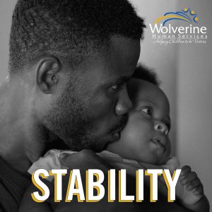 ma holding baby with word "stability" overlaid